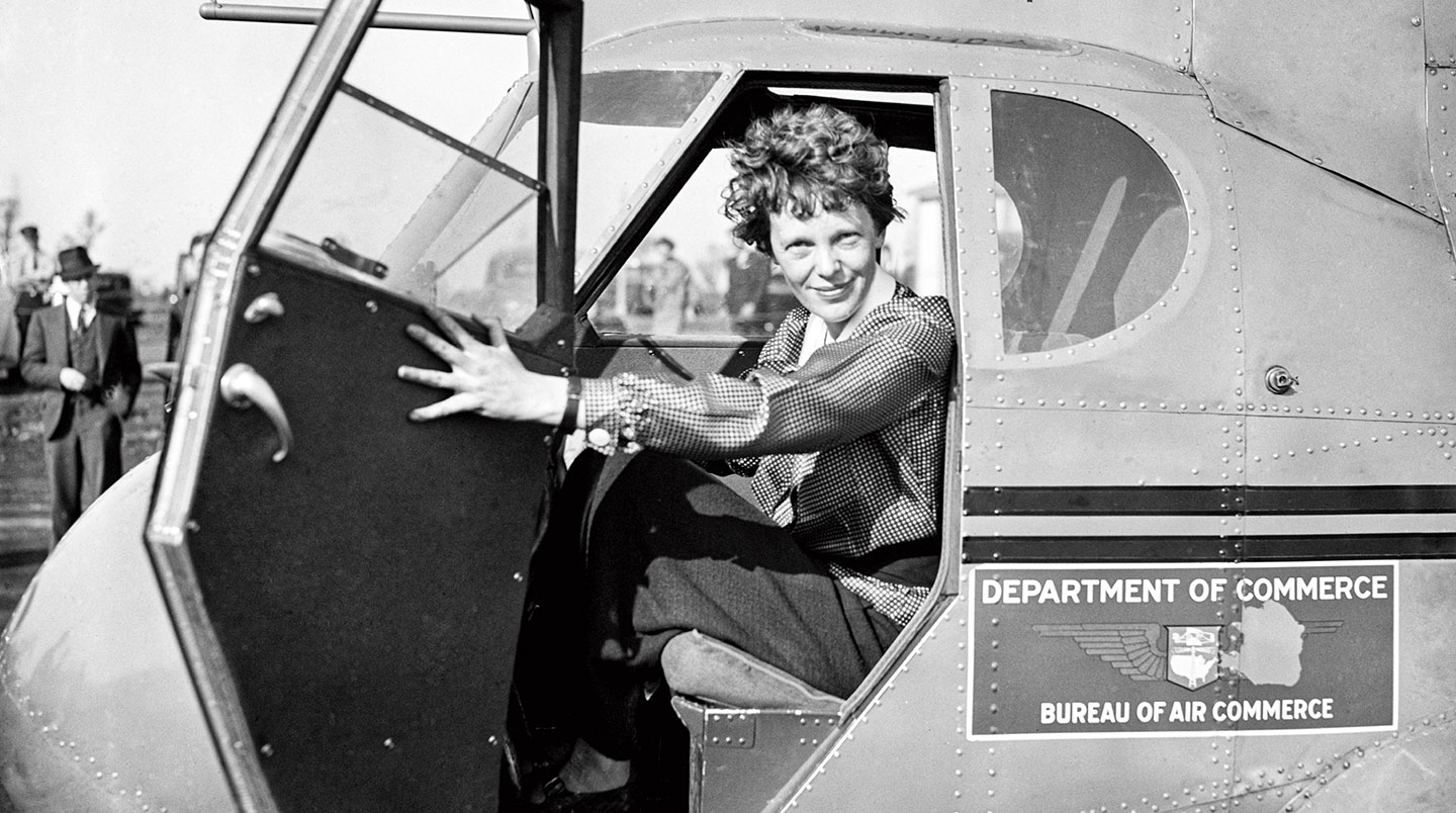 Amelia Earhart smiles from inside her airplane
