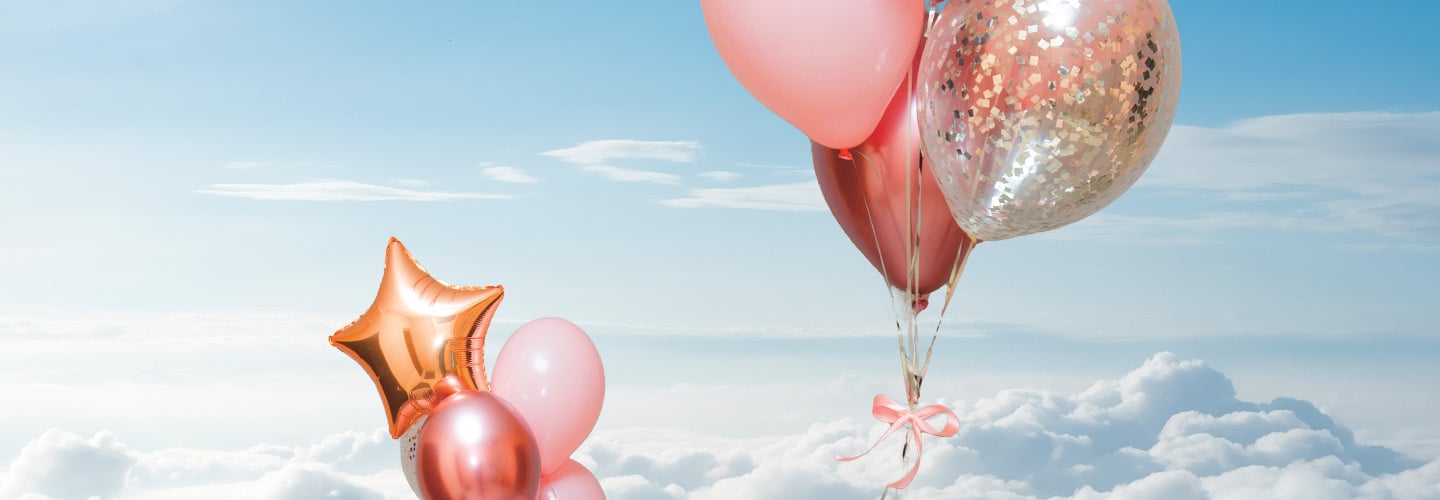 Image of pink balloons floating high into the sky